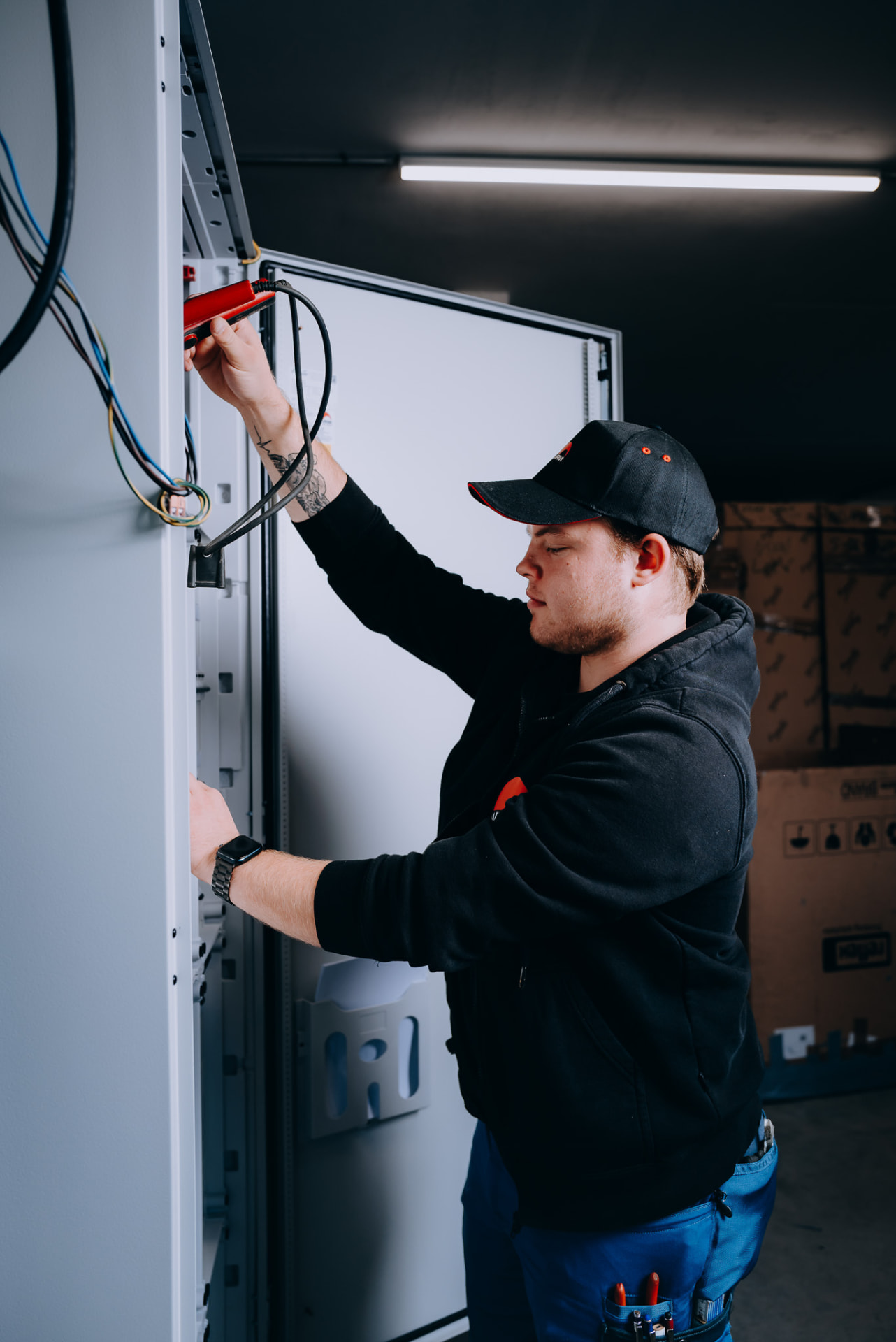 Elektroniker setzt Messgerät an der Schaltanlage an