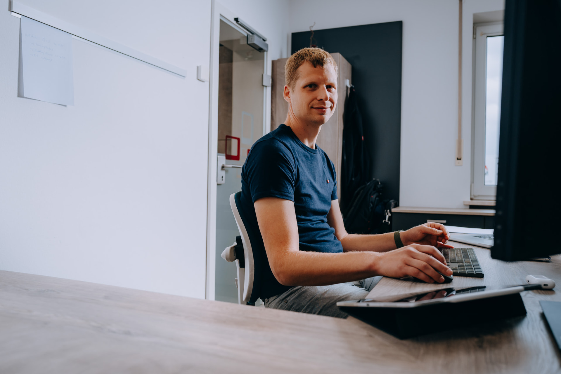 Mitarbeiter am Doppelarbeitsplatz mit Laptop und Monitor