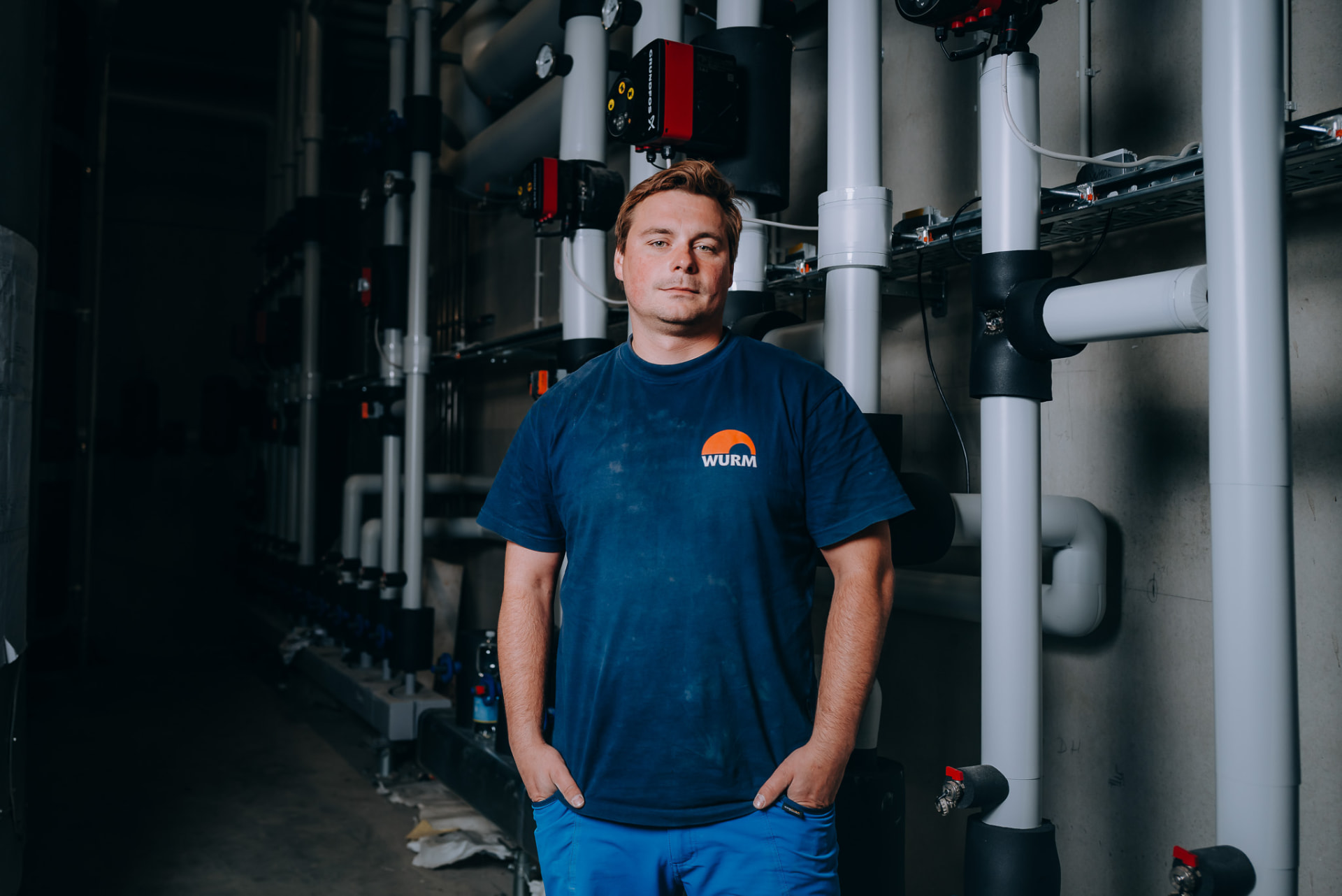 Anlagenmechaniker der Wurm GmbH im Technikraum vor Pumpengruppen