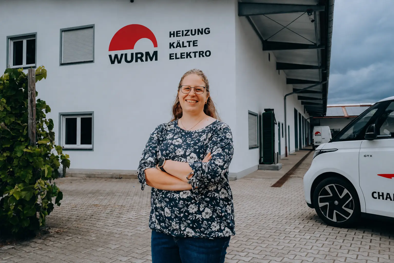 Portrait einer Mitarbeiterin vor dem Firmengebäude