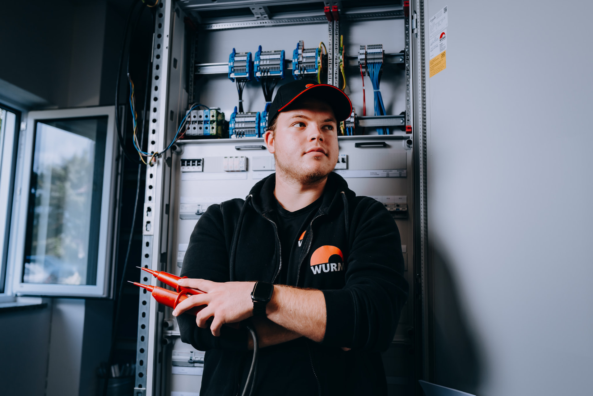Elektroniker der Wurm GmbH vor fertig verdrahtetem Schaltschrank