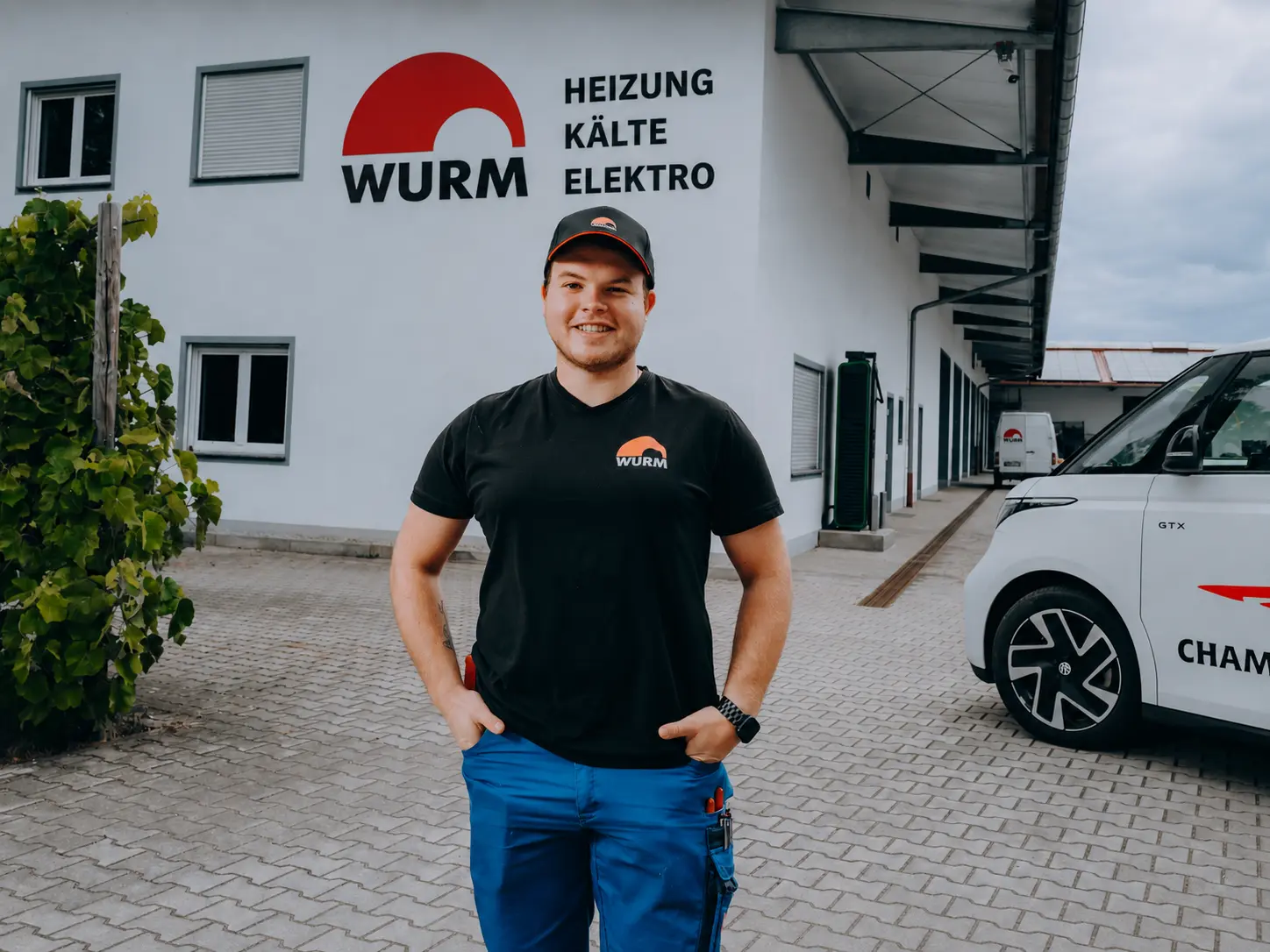 Portrait eines jungen Monteurs in Wurm-Arbeitskleidung