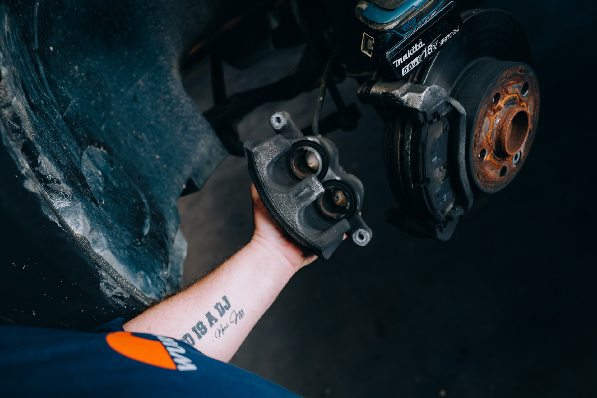 Ausgebauter Bremssattel in der Hand des Mechanikers