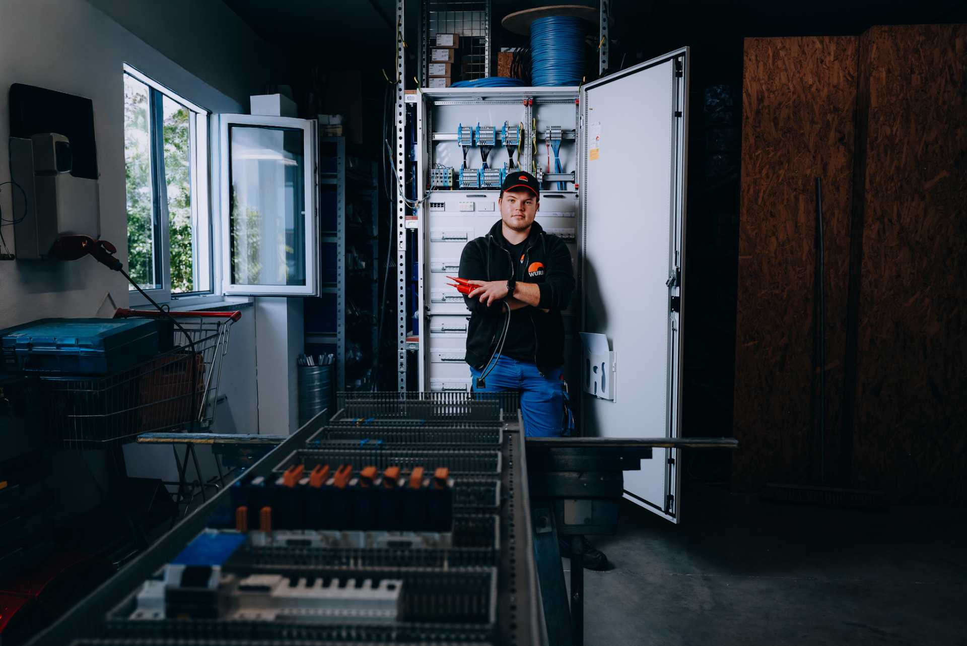 Blick in die Schaltanlagenfertigung mit Elektroniker am Schrank
