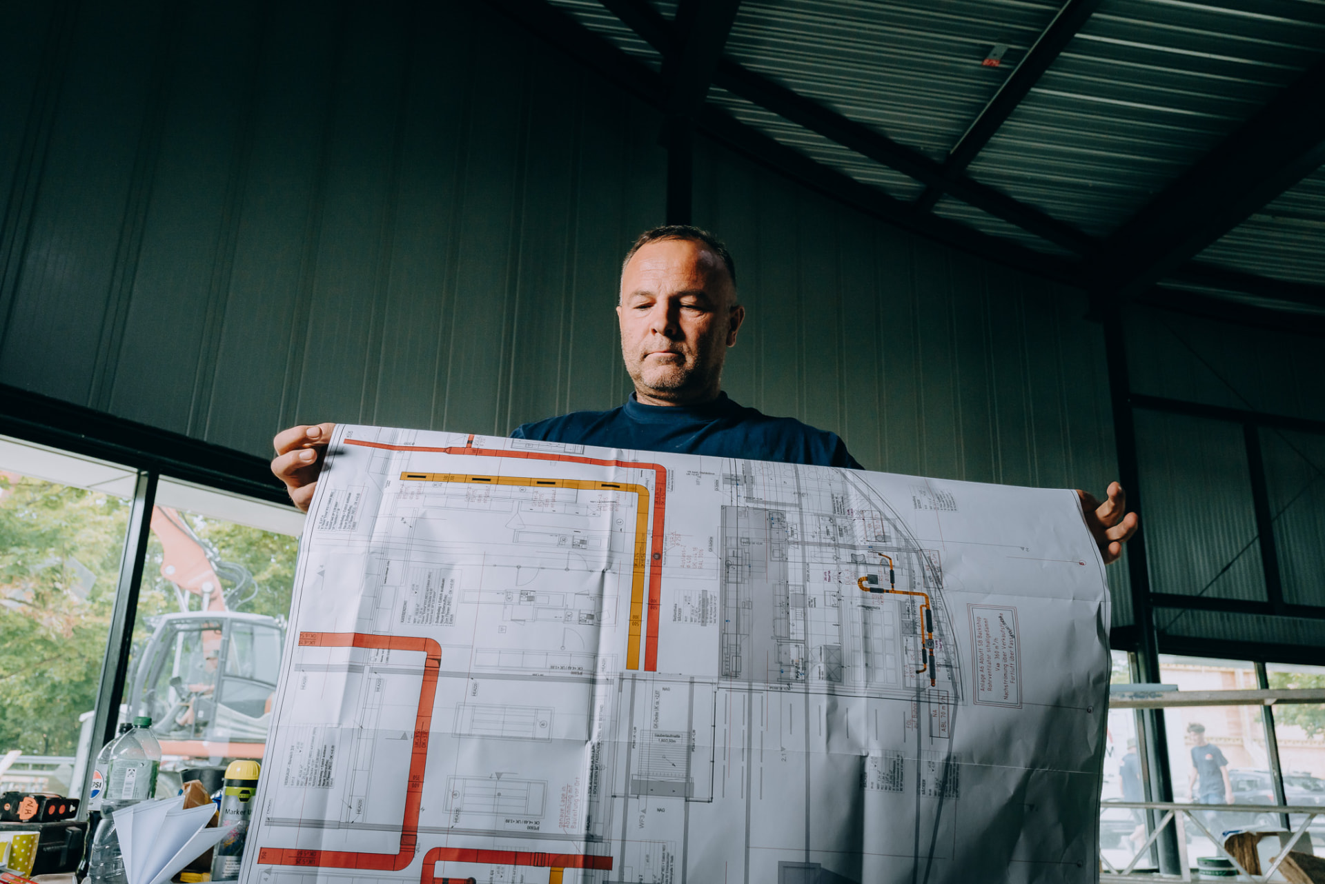 Monteur der Wurm GmbH hält einen großformatigen Installationsplan