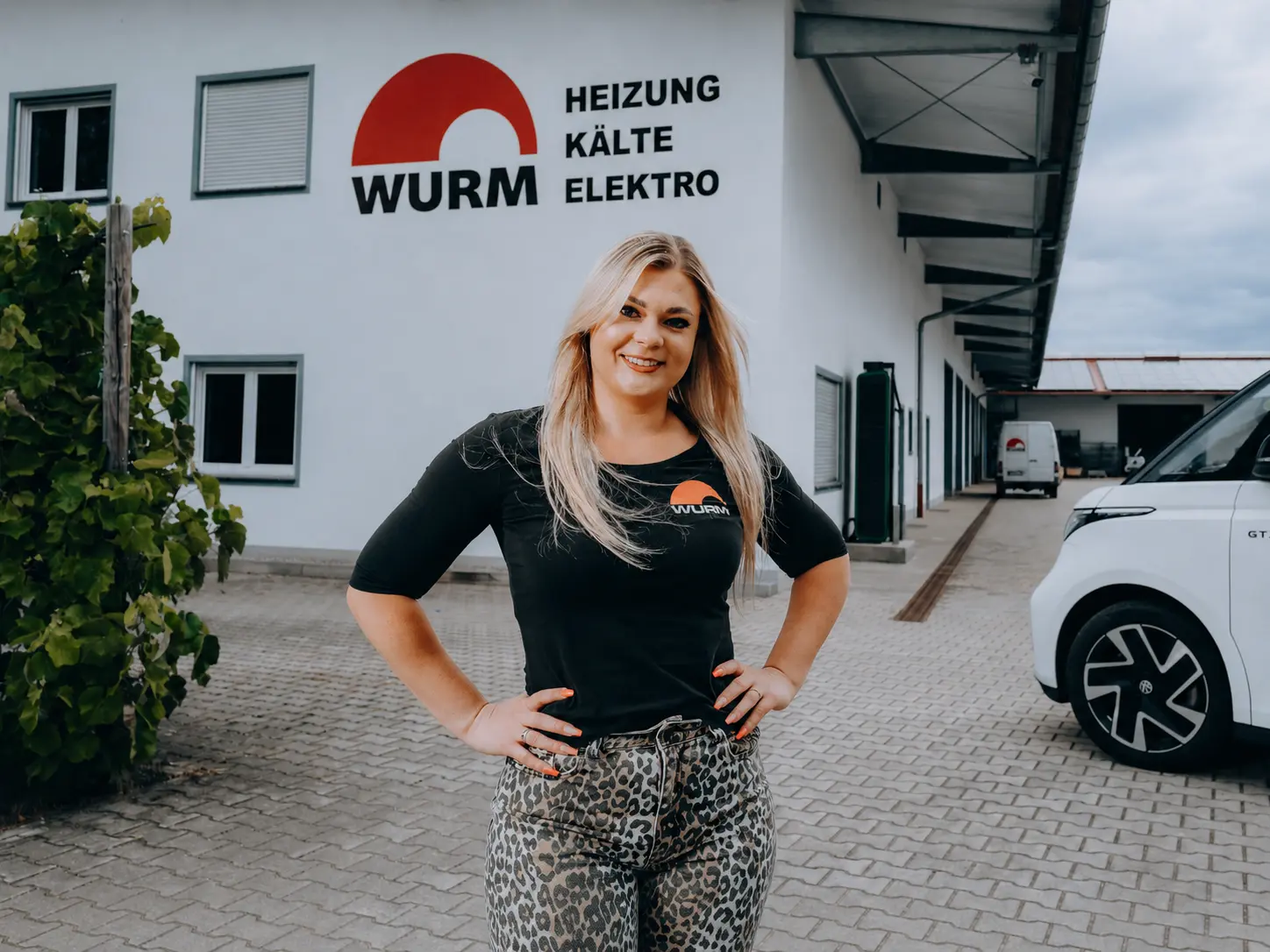 Portrait einer Mitarbeiterin im Wurm-Shirt vor dem Betrieb