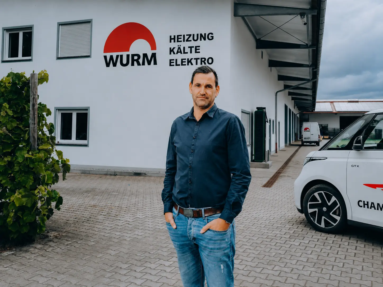 Portrait vor dem Firmengebäude mit Wurm-Logo an der Fassade