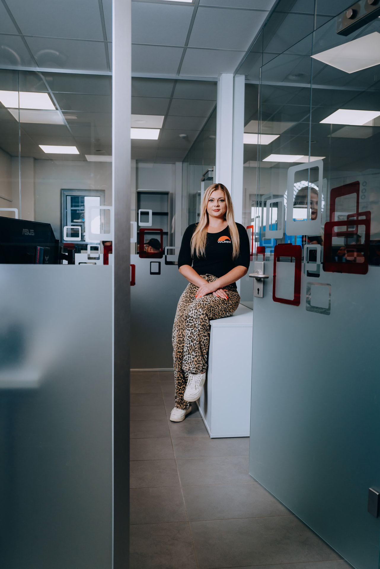 Mitarbeiterin im Büro zwischen Glastrennwänden