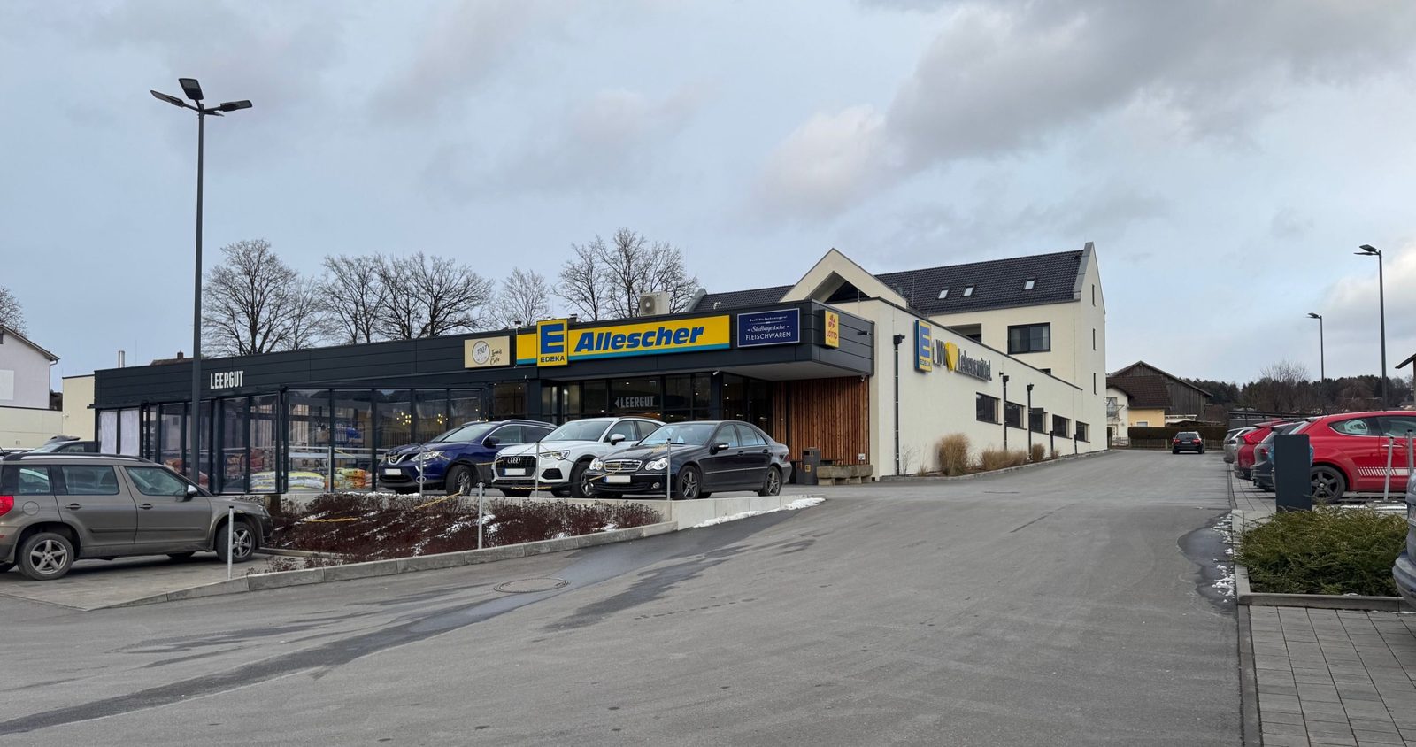 Außenansicht des neu gebauten Lebensmittelmarkts Edeka Katzbach in Katzbach mit Parkplatz und Zufahrt.