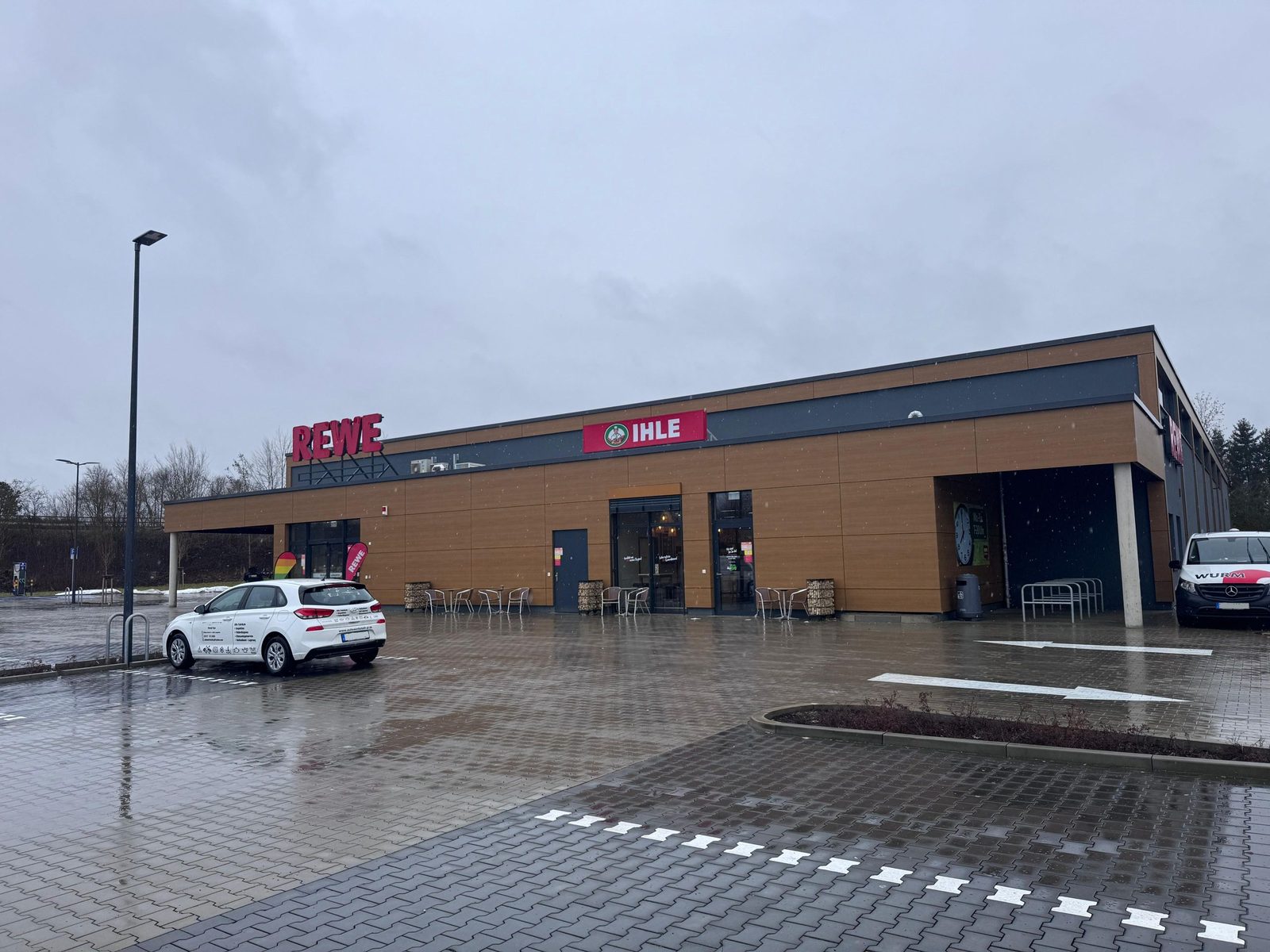 Außenansicht des Neubaus Rewe Nordendorf in Nordendorf mit Parkplatz und Servicefahrzeug.
